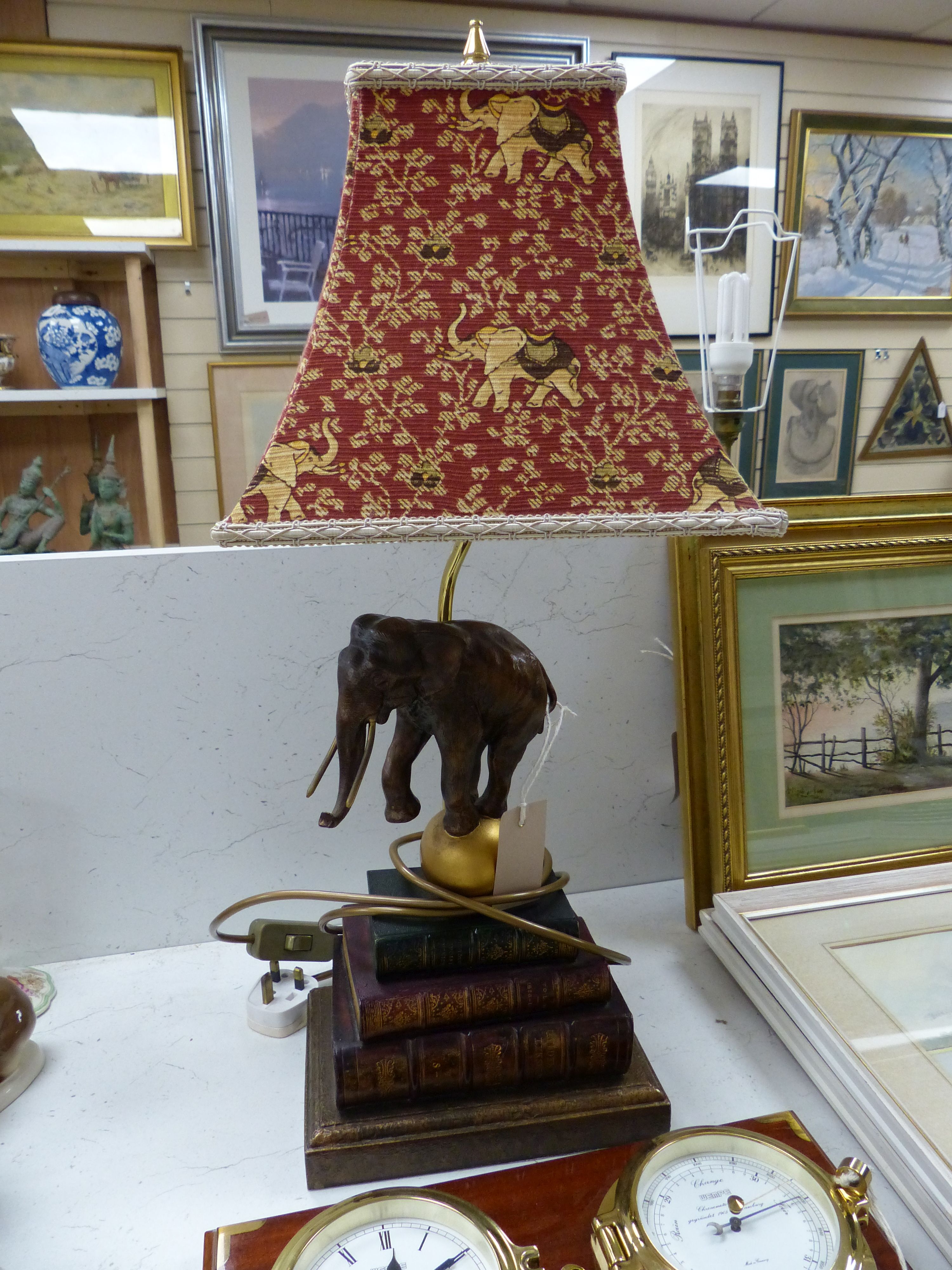 A Wempe wall-mounted ship's style clock/barometer and an 'elephant on books' table lamp